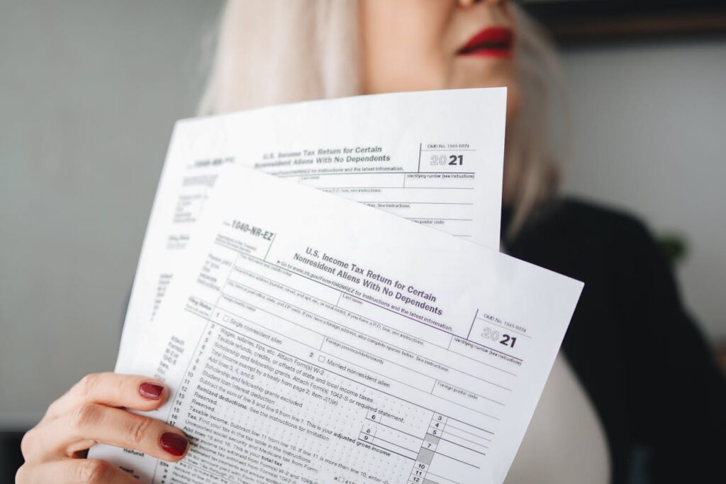 pexels photo 6927565 A woman holds U.S. tax documents with a blurred background, implying focus on paperwork.