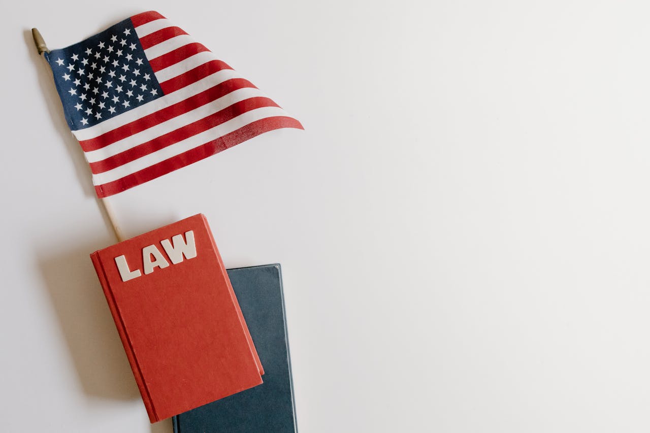 services-01 Flat lay of an American flag and a law book symbolizing justice and patriotism.